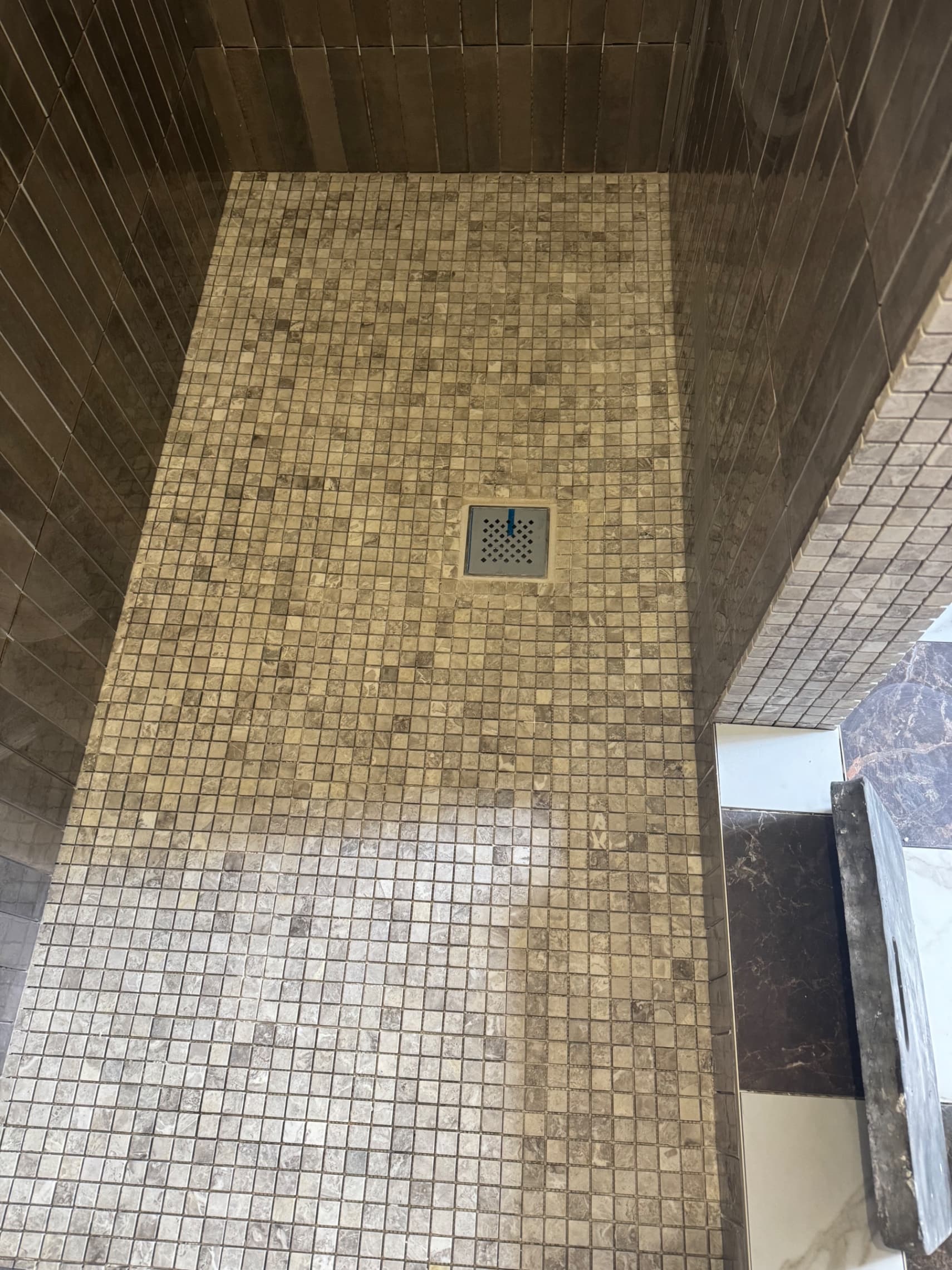 We've laid this marble mosaic floor in the shower area, with the tiles sloping naturally towards the drain for perfect water drainage. The natural stone creates a really striking feature underfoot.
