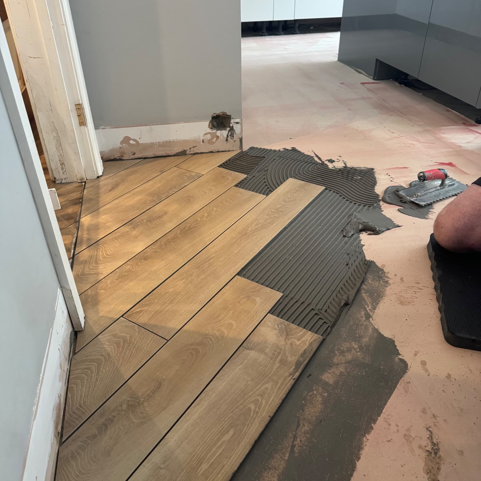 We've got the first tiles down and we're working our way out from the garage conversion floor we laid previously. The edges and doorways always take a bit longer to set out properly, but once we reach the open areas the pace picks up considerably.